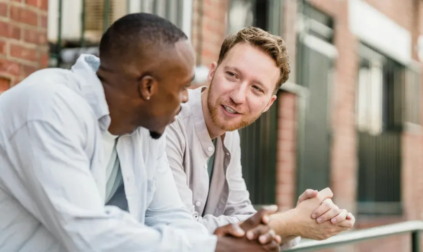 Two men having a friendly, supportive conversation outdoors in the neighborhood