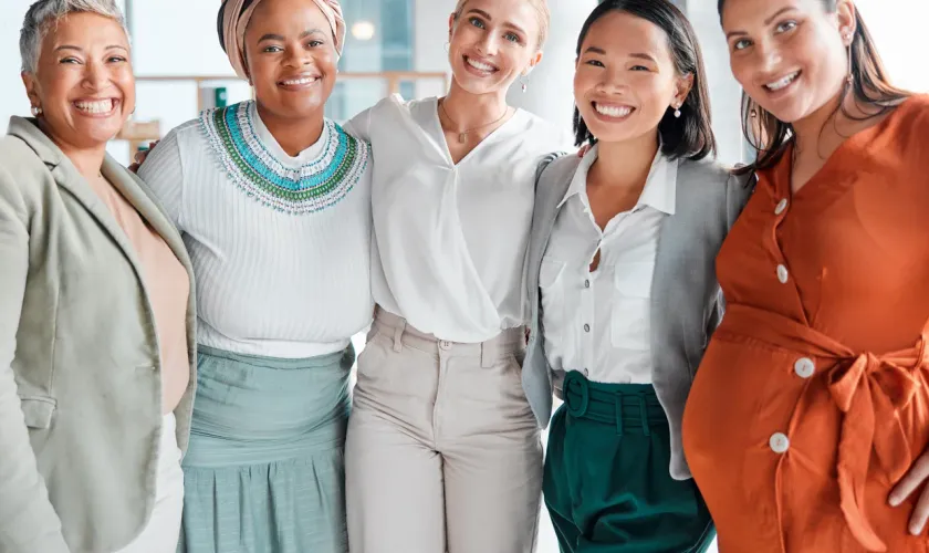 A group of five diverse women of different ages smiling together